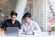 © amnaj - Two young asian businessman using laptop working at office on new project.