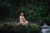Fototapeta  - Yoga practice and meditation in nature. Man practicing near river