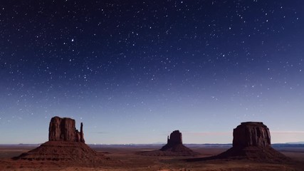 Wall Mural - time lapse of the stars moving across the night sky above monument valley