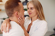 © prostooleh - Cute couple in a kitchen. Lady in a white shirt. Pair at home