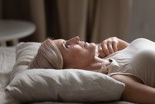 Sleepless Mature Woman Lying In Bed, Suffering From Insomnia