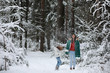 © alexkich - Young family for a walk. Mom and daughter are walking in a winter park.