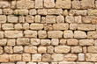 Tufa wall texture, highly porous, water eroded, hand cut stone blocks forming old wall, part of medieval abbey in south of france