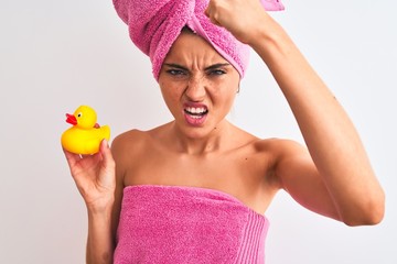 Poster - Young beautiful woman wearing shower towel holding duck over isolated white background annoyed and frustrated shouting with anger, crazy and yelling with raised hand, anger concept