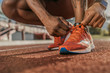 Close up shot of hands tying shoelaces sneaker on the running track. Getting ready to jogging.