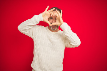 Sticker - Handsome middle age senior man with grey hair over isolated red background Doing heart shape with hand and fingers smiling looking through sign