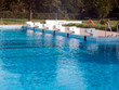 Startblöcke am Beckenrand von einem Schwimmbad. Die Blöcke tragen die Nummer eins, zwei, drei, vier, fünf und sechs. Die Startblöcke werden für Schwimmwettbewerbe genutzt .