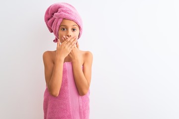 Poster - Beautiful child girl wearing shower towel after bath standing over isolated white background shocked covering mouth with hands for mistake. Secret concept.