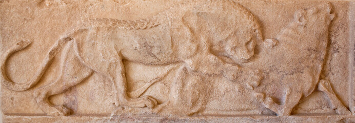 Wall Mural - Ancient bas-relief with a scene with lion attacking a bull