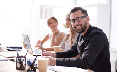 Wall Mural - smiling businessman in the workplace in the office