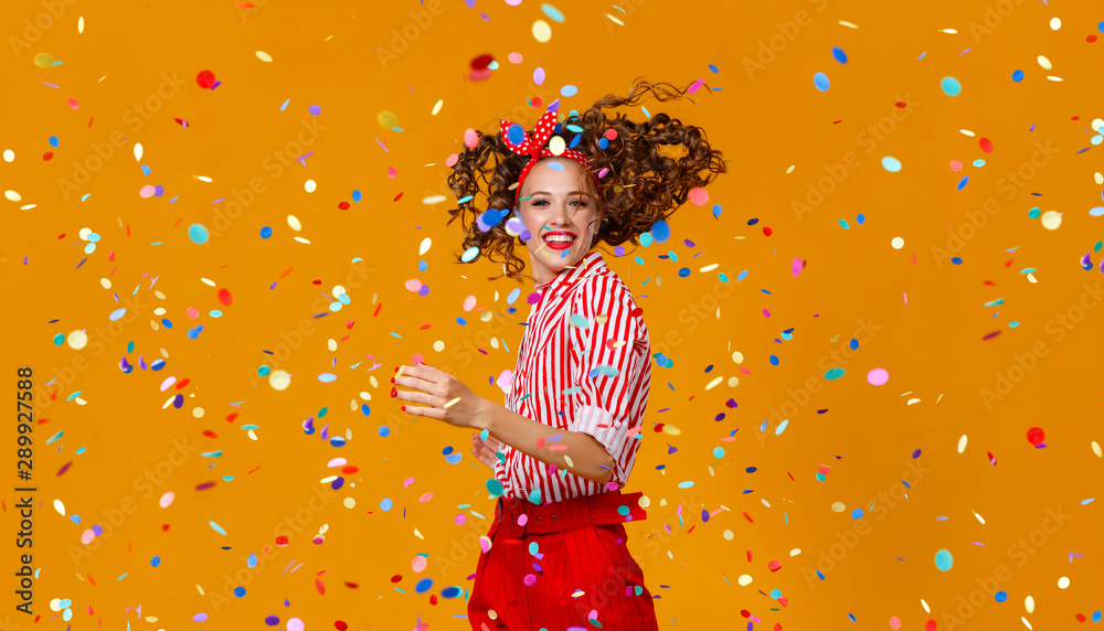 cheerful funny young woman with festive confetti on yellow - obrazy, fototapety, plakaty 