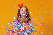 © JenkoAtaman - cheerful funny young woman with festive confetti on yellow