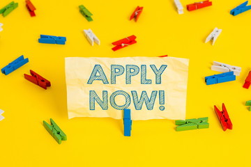 Writing note showing Apply Now. Business concept for request something officially in writing or by sending in form Colored clothespin papers empty reminder yellow floor background office