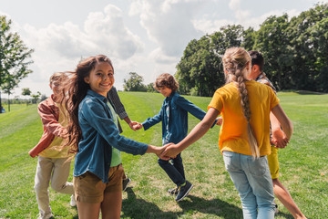 Wall Mural - selective focus of happy multicultural kids holding hands