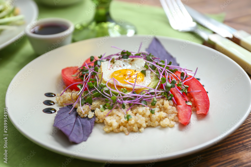 Plate with tasty salad on table
