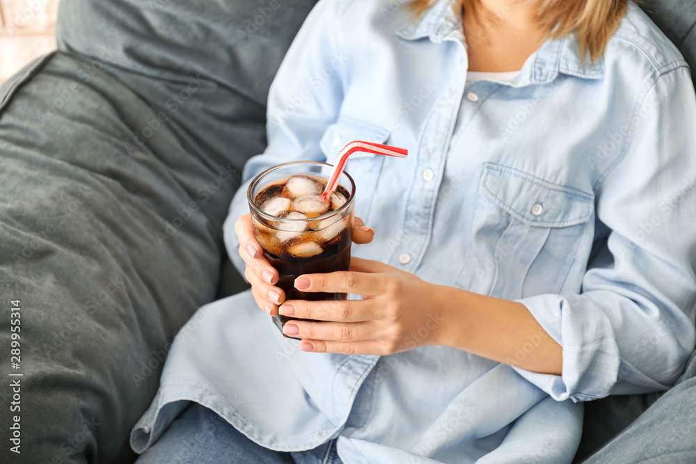 Woman drinking tasty cola at home