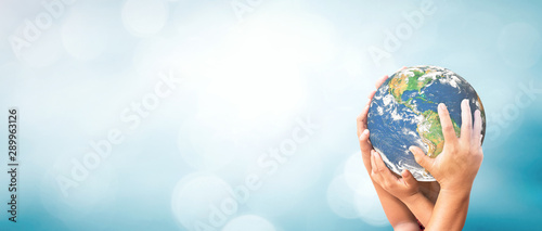 Fotografía World environment day concept: Earth globe in family hands over blurred nature background
