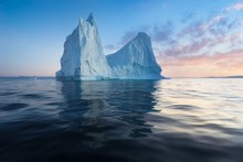 Iceberg At Sunset. Nature And Landscapes Of Greenland. Disko Bay. West Greenland. Summer Midnight Sun And Icebergs. Big Blue Ice In Icefjord. Affected By Climate Change And Global Warming.