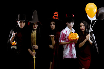 Group young Asian in costume Halloween party on black background.