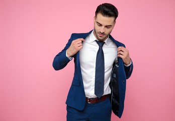 Wall Mural - handsome casual man holding coat and looking down