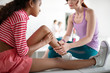 © zinkevych - Dark-skinned girl with knee ache sitting near PE teacher