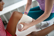 © zinkevych - Teacher providing first aid while putting bandage on knee