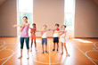 © zinkevych - PE teacher and children stretching arms before starting physical training