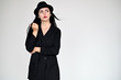© Вячеслав Чичаев - Concept portrait of a pretty brunette girl with long black hair in a hat and a business suit on a white background in studio. Standing right in front of the camera in various poses.