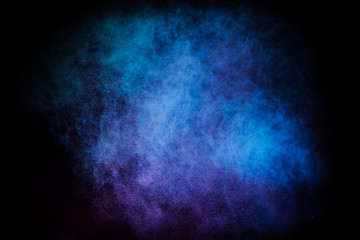 Wall Mural - freeze motion of colored dust explosion isolated on black background.