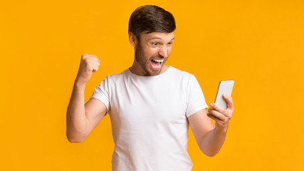 Poster - Happy Man Holding Cellphone Shaking Fists Celebrating Success, Panorama