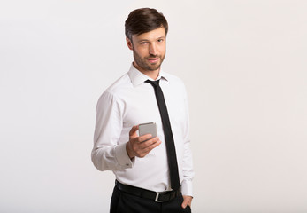 Poster - Man Holding Cellphone Standing On White Background