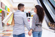 © Prostock-studio - Loving couple walking with shopping bags in city mall