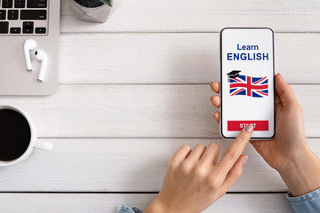 Woman holding smartphone with application for learning English on screen
