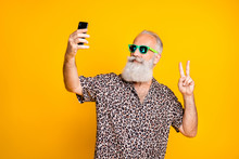 Portrait Of Positive Funny Funky Old Long Bearded Man On Travel Summer Holidays Trip Make Selfie V-signs Wear Eyewear Eyeglasses Isolated Over Yellow Background