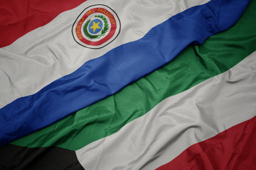 waving colorful flag of kuwait and national flag of paraguay.