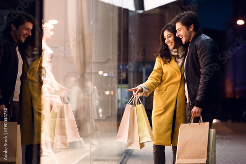 Cuadros en Lienzo Window shopping. Couple looking at fashion store's showcase
