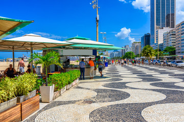 Fototapete - View of Copacabana beach with palms and mosaic of sidewalk in Rio de Janeiro, Brazil. Copacabana beach is the most famous beach in Rio de Janeiro. Sunny cityscape of Rio de Janeiro