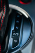 Close up of the automatic gearbox lever, black and red interior sports car; Automatic transmission gearshift stick;