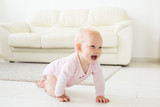 Fototapeta  - Smiling crawling baby girl at home on floor