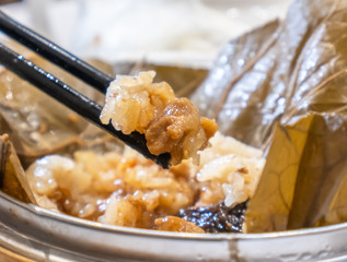 Wall Mural - Delicious Lo Mai Gai dim sum, fresh steamed glutinous rice with chicken roll wrapped by lotus leaf in bamboo steamer in hong kong yumcha restaurant.