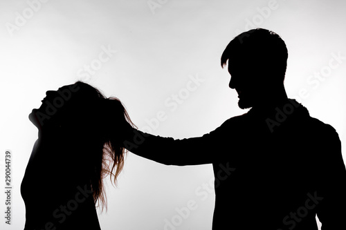 Cuadros en Lienzo Aggression and abuse concept - man and woman expressing domestic violence in studio silhouette isolated on white background