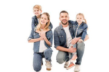  happy family in jeans embracing and smiling isolated on white