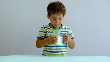 Wall Mural - slow motion asian Cute little kid drinking milk on kitchen. cheerful boy likes to drink milkshake