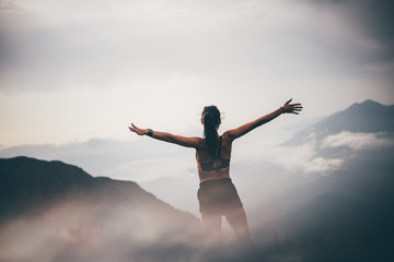 Running woman on top of mountain happy and celebrating success. Woman n the nature mountain scenery. Concept of healthy lifestyle. Fitness spot girl training in mountain.