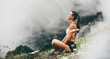 Woman meditating on mountain cliff above the clouds. Alone travel healthy lifestyle. Healthy life Concept.
