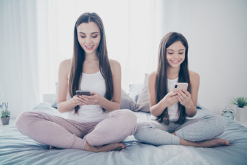 Poster - Portrait of two nice-looking beautiful attractive lovely charming feminine focused cheerful cheery long haired people sitting on sheets lotus pose in light white interior room house indoors