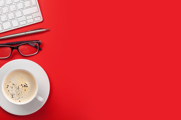 Office red workplace with coffee cup, supplies and computer