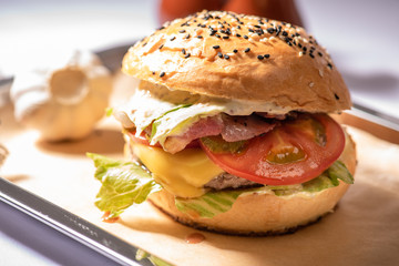 Wall Mural - hamburger with beef patty tomato bacon cheese with blurry background