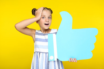 Wall Mural - Beautiful girl holding paper thumb up on blue background