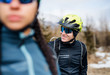 © Halfpoint - Two mountain bikers standing on road outdoors in winter.